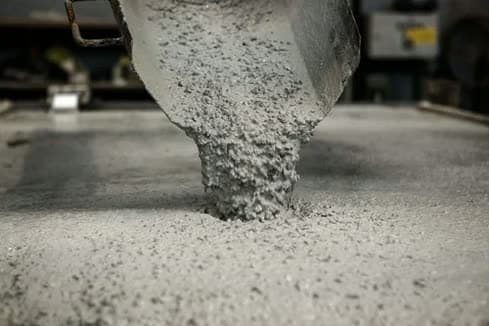 Fresh concrete discharging from a chute onto a slab