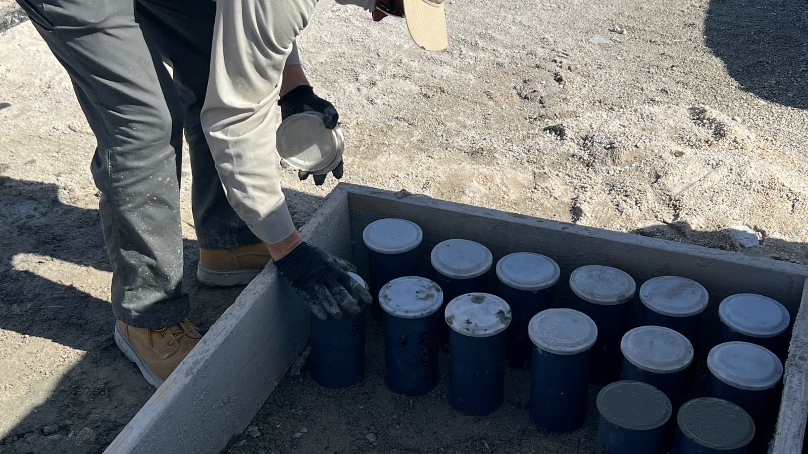 Technician filling concrete test cylinders on a jobsite
