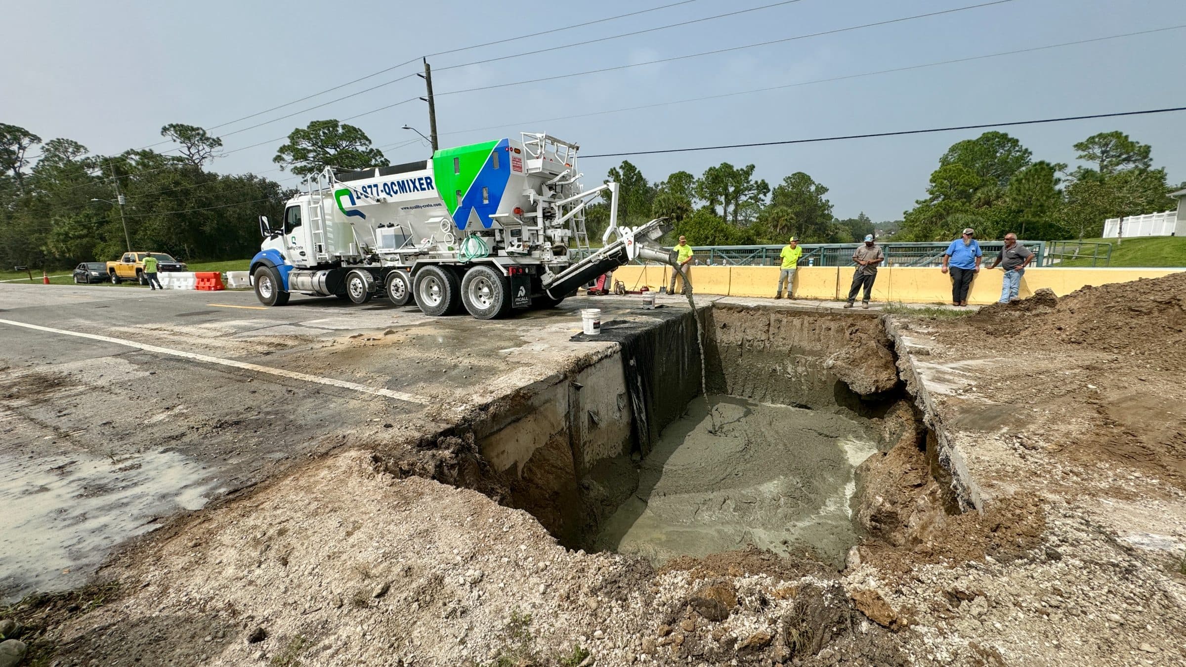 Quality-Crete mixer beside an open excavation