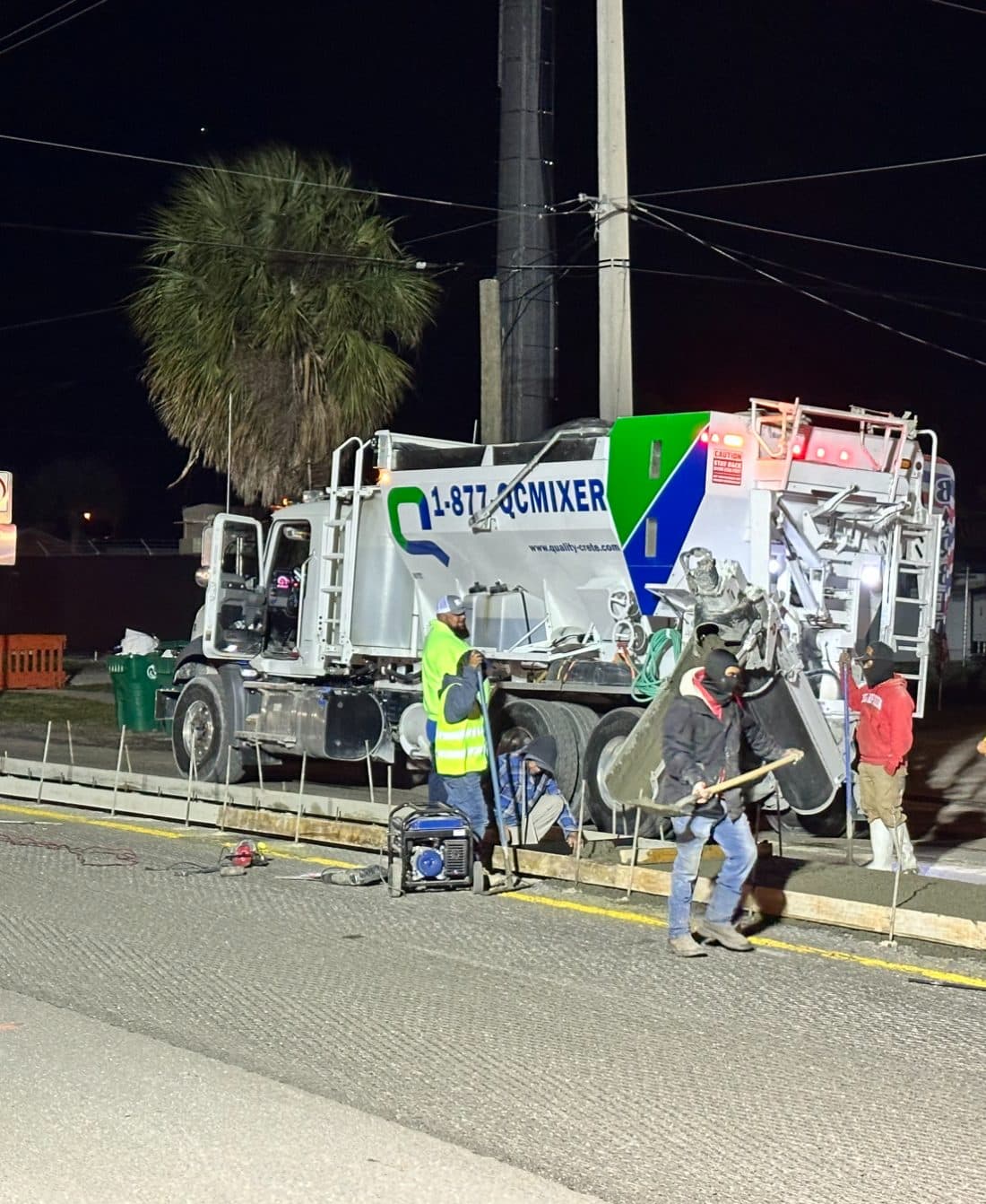 Quality-Crete mixer and crew on a night roadway pour