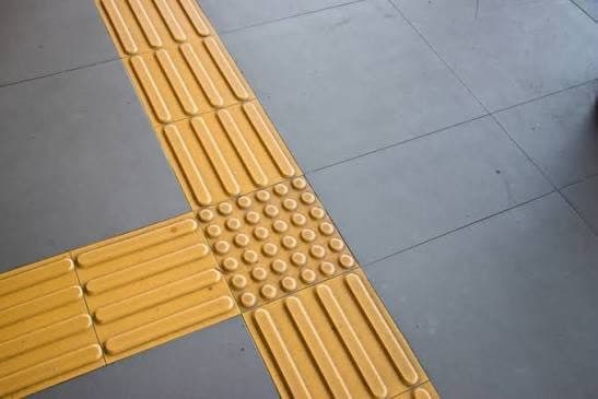 Yellow detectable warning tiles set in concrete