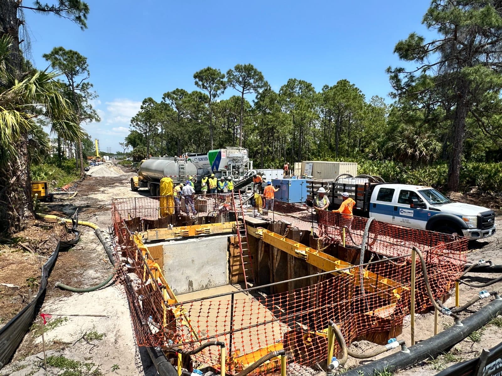 Crew working inside a formed utility vault beside a roadway