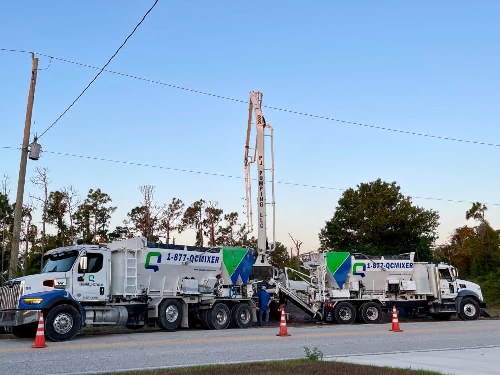 Row of Quality-Crete volumetric mixers staged on a residential site