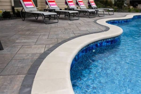 Curved pool coping beside a paver deck