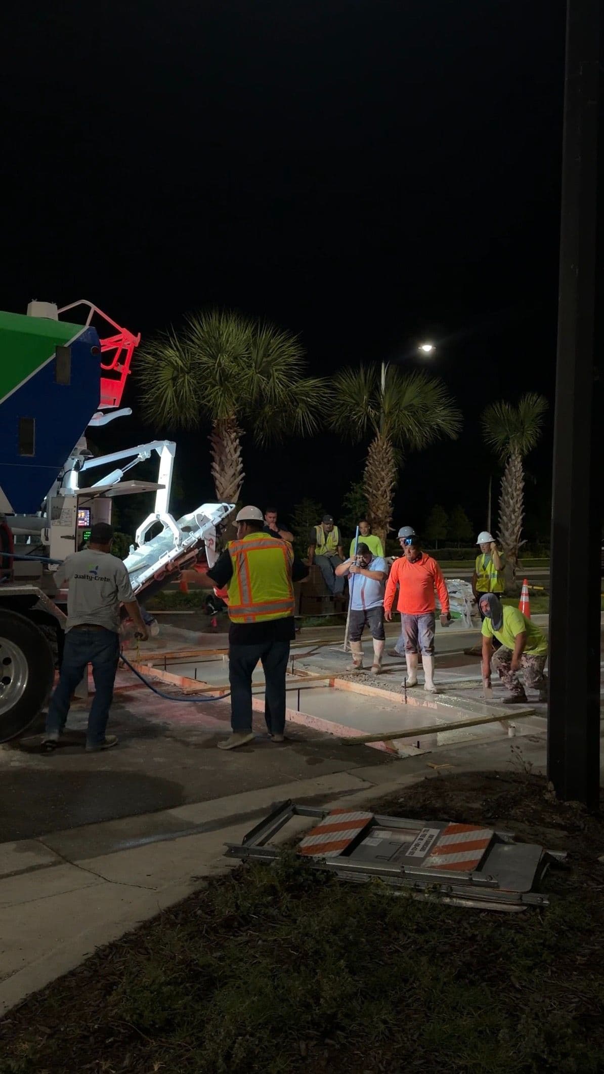 Night-time road repair crew placing rapid set concrete